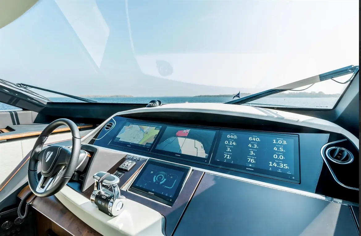 Luxury yacht cockpit with modern digital displays showing navigation, speed, and telemetry metrics, against a seascape backdrop.